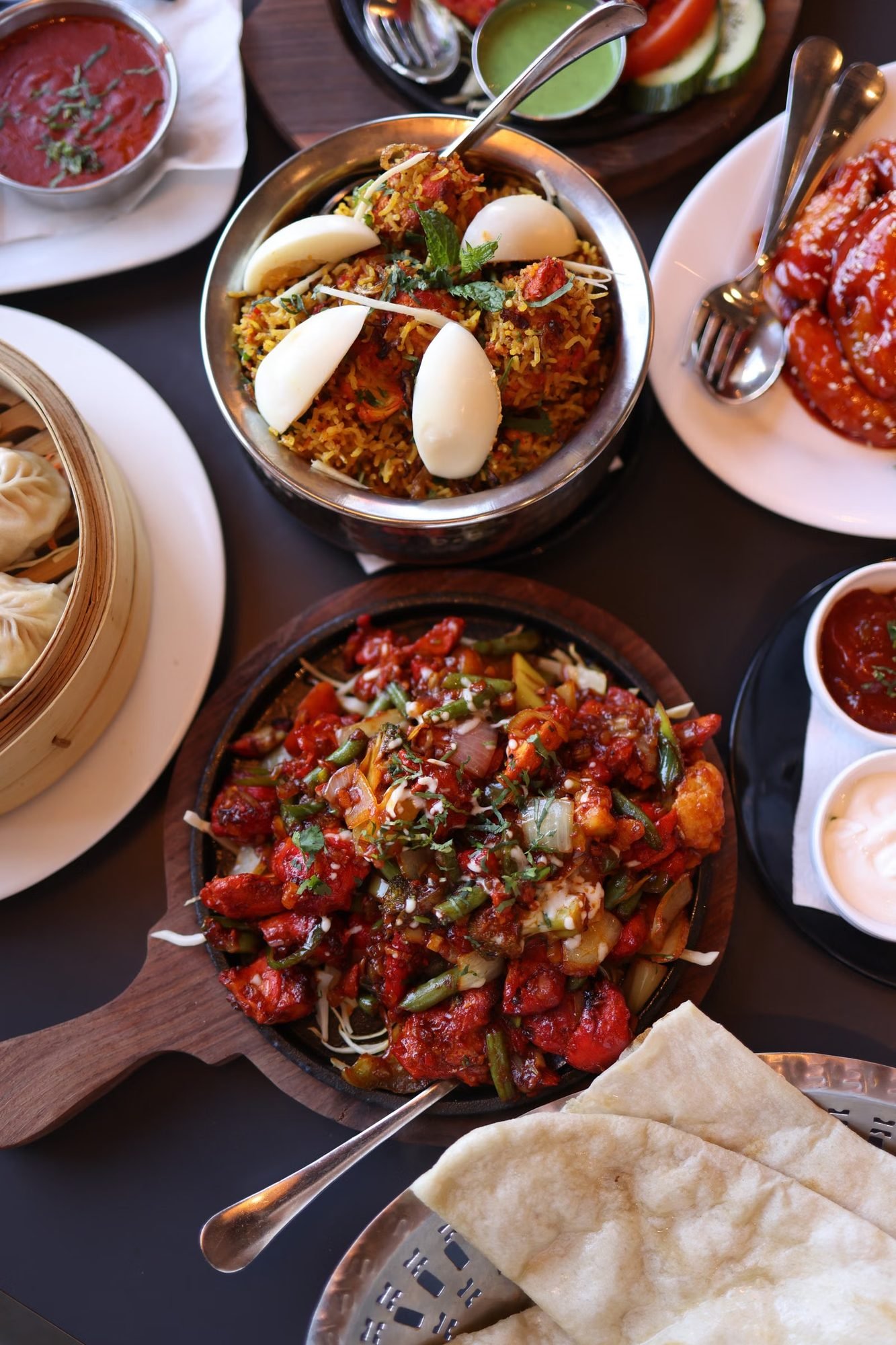 A spread of biryani, curries and starters laid out across a table