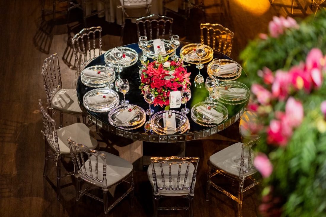 An overhead view of a laid reception table with a floral centrepiece