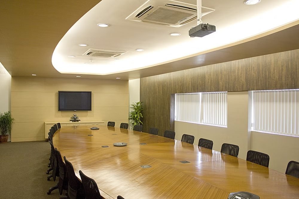 A boardroom laid out for a corporate meeting, chairs set around a long table