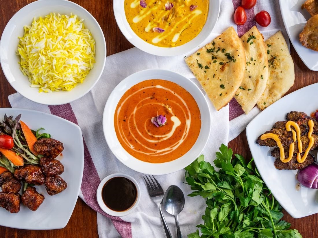 An array of curries, biryani and naan set out across a table