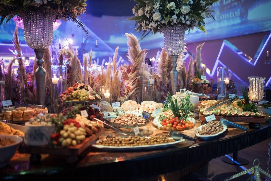 A lavishly dressed banquet table laid with a full spread of dishes and floral arrangements